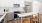 Tracy CA Apartments for Rent - The Vela - Bright Kitchen with White Cabinetry, Stainless Steel Appliances, White Countertops, Wood-Style Lower Cabinetry, Cooking Island with Seating, and Wood-Style Flooring