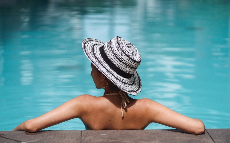 lifestyle image of a person sitting in a pool looking over her shoulder